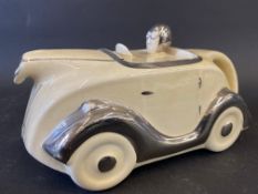 An Art Deco cream glazed teapot in the form of a stylish racing car, impressed registration number