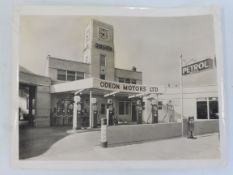 A black and white photograph of the Art Deco Odeon Motors Ltd garage, with a row of six petrol pumps