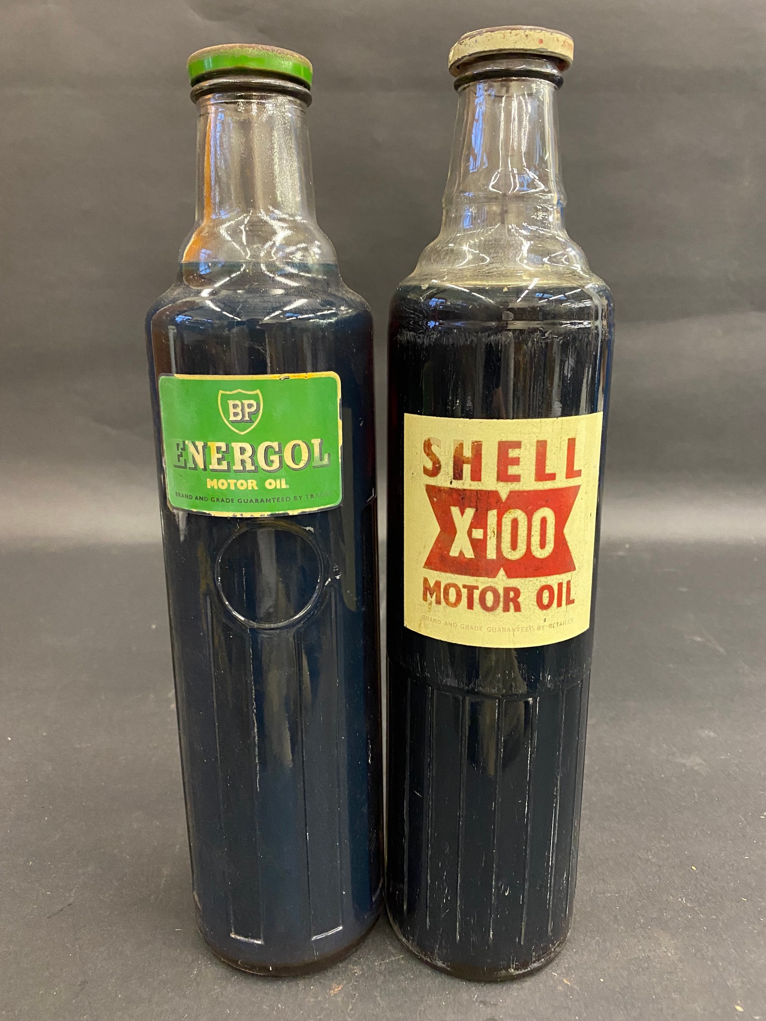A Shell X-100 quart oil bottle plus a BP Energol quart bottle.