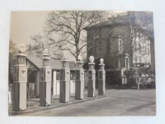A fabulous period photograph of a garage forecourt, six petrol pumps serving different brands of