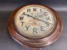 A Warwick Tyres circular advertising wall clock with pendulum and key.