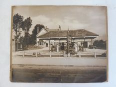 A large photograph of a garage forecourt, with a row of five petrol pumps with Cleveland, Power,