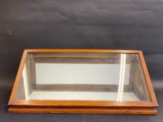 An oak sloping forward table top display cabinet with lift-up glass lid and fold down rear door, 29"