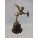 A polished brass accessory mascot in the form of a winged cherub, display base mounted.