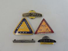 Two Morris Commercial triangular lapel badges, and three others.