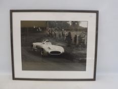 A framed and glazed black and white photograph of Stirling Moss during a Mercedes-Benz 300 LR,