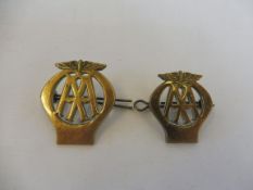 Two different sized AA brass cap badges.