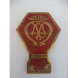 An AA brass and painted commercial badge with basketweave background stamped V53 696, shortened foot