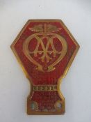 An AA brass and painted commercial badge with basketweave background stamped V53 696, shortened foot