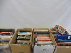 An extensive collection across four boxes of Formula 1 and other motor racing related books.