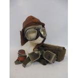 A leather flying helmet plus various pairs of goggles.