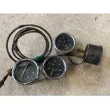 Three black faced oil gauges and a temperature gauge.