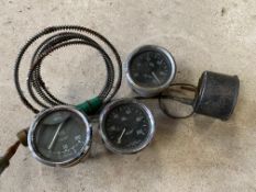 Three black faced oil gauges and a temperature gauge.