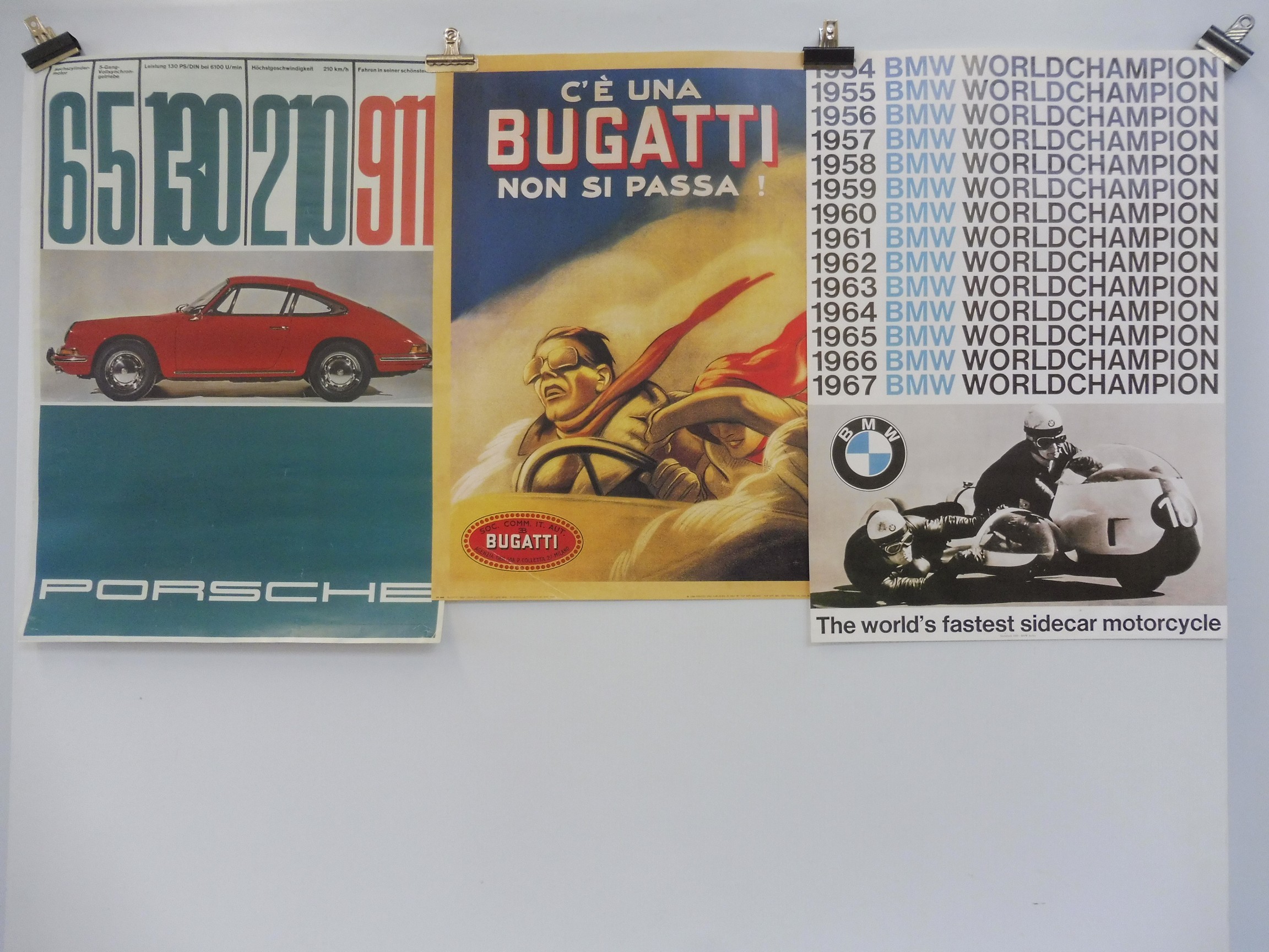 A BMW Archive 1999 reproduction poster, a second for Porsche and a third for Bugatti.