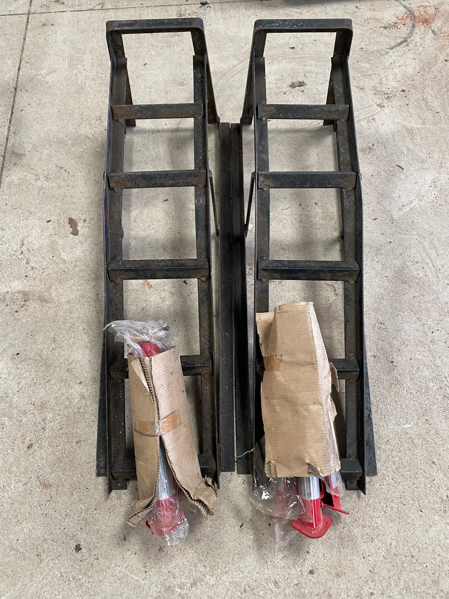 A pair of car ramps and a pair of new folding axle stands.