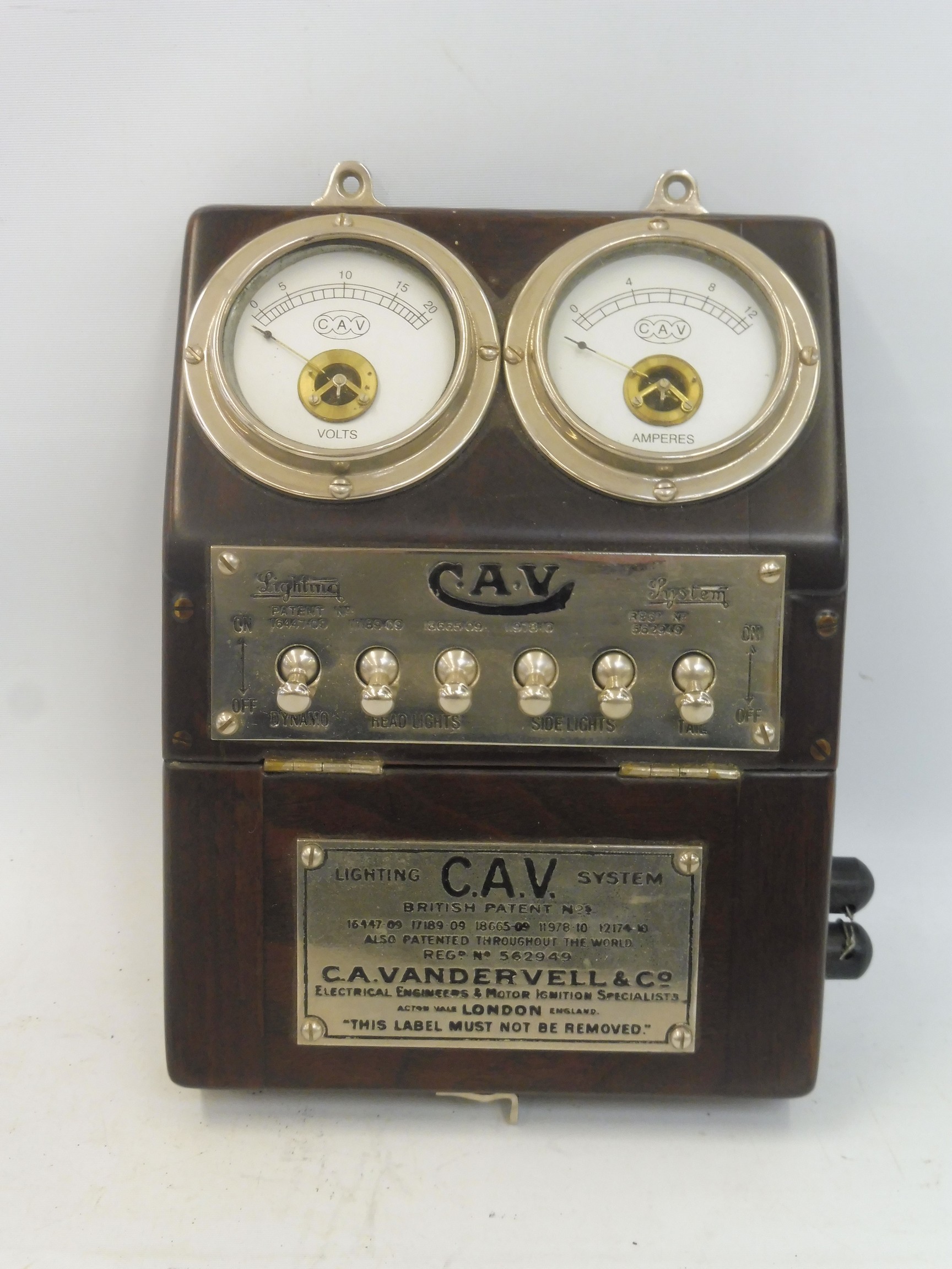 An Edwardian CAV bulkhead mounted switch panel, showing a voltmeter adjacent to an ammeter, above