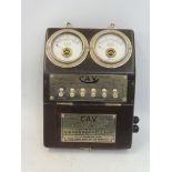 An Edwardian CAV bulkhead mounted switch panel, showing a voltmeter adjacent to an ammeter, above