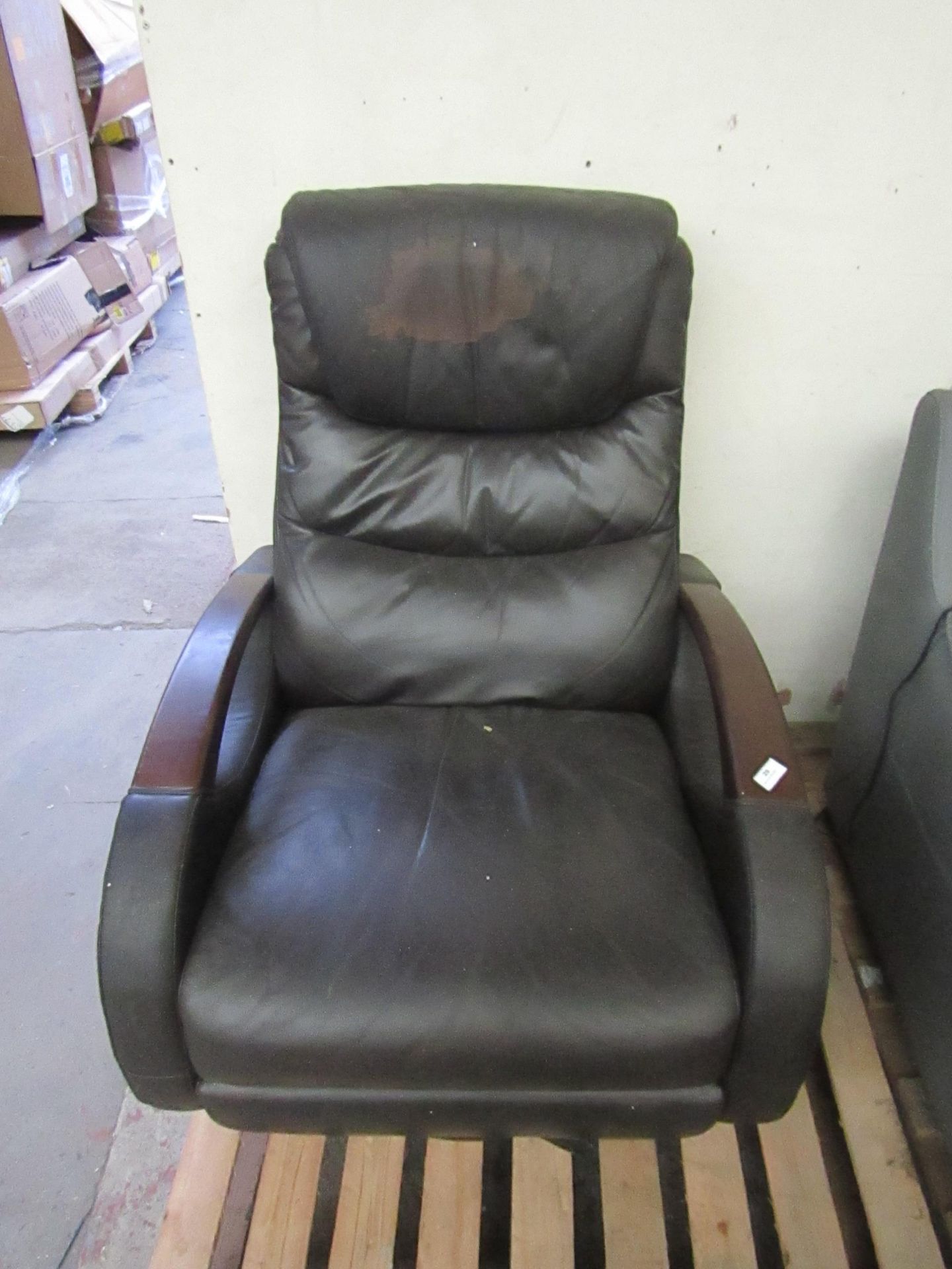 Brown leather revolving reclinging arm chair, the recline arm is missing, the foot mechanism is