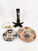 Oriental shallow dish, a very decorative carved wooden plate stand, and 2 other plates