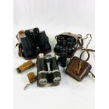 Four pairs of binoculars and a telescope lens in a case