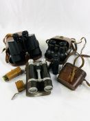 Four pairs of binoculars and a telescope lens in a case