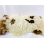 Brown and white animal skin style rug.