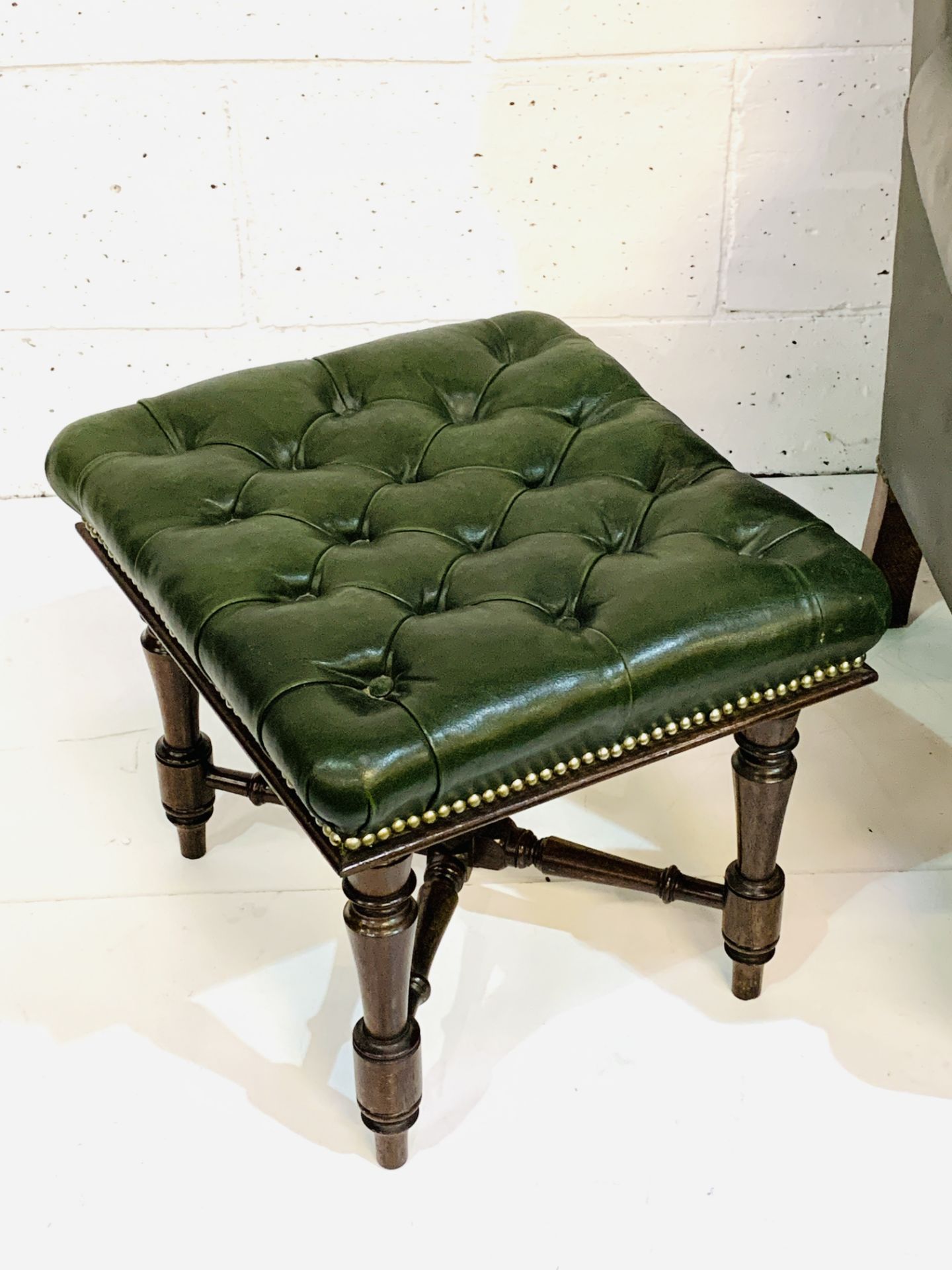Green brass studded button back leather upholstered wing back armchair with a similar footstool. - Image 6 of 7