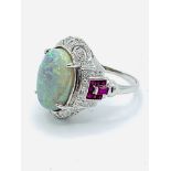 18ct white gold opal set ring with rubies and diamonds to shoulders.