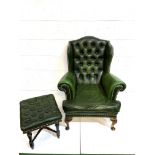 Green brass studded button back leather upholstered wing back armchair with a similar footstool.