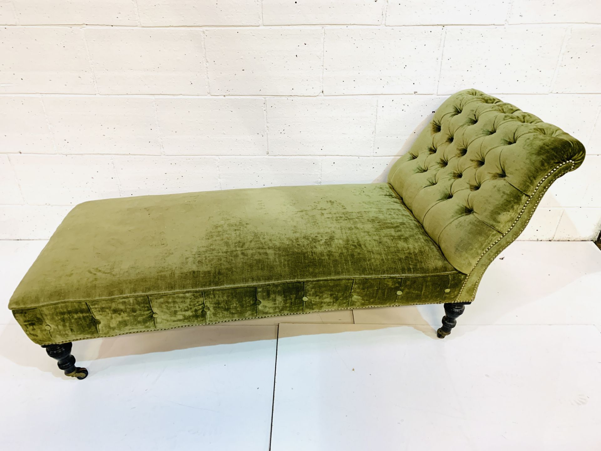 Green velvet button back upholstered chaise lounge.