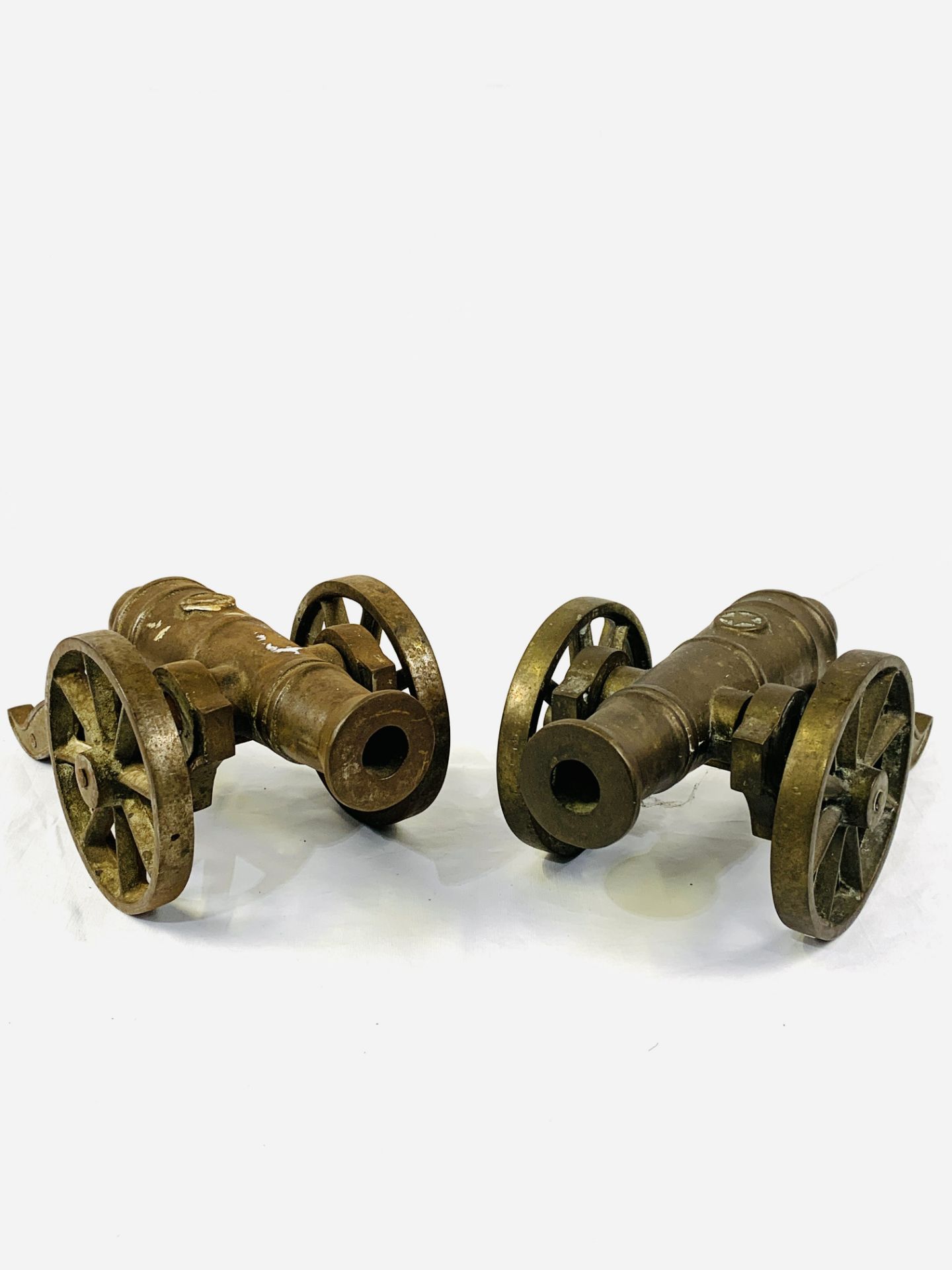 A brass model cannon together with a white metal cannon to match