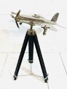 Chrome model aeroplane on tripod stand.