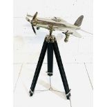 Chrome model aeroplane on tripod stand.