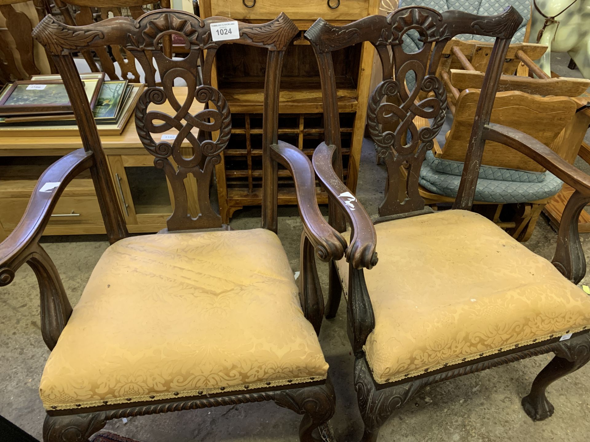 Pair of carved mahogany open arm chairs