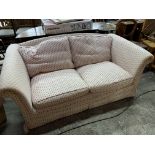 Cream and pink upholstered two seat sofa