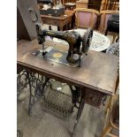 Singer vibrating shuttle treadle sewing machine on wooden table . This item carries VAT.