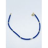 Bead and blue rubber bracelet with yellow gold clasp