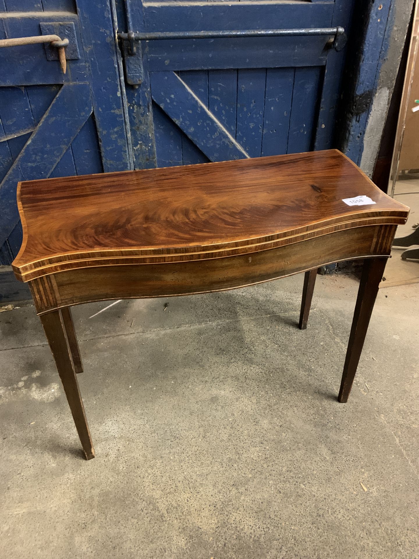 Mahogany serpentine fronted, fold over top, gate leg tea table, on tapered legs. This item carries