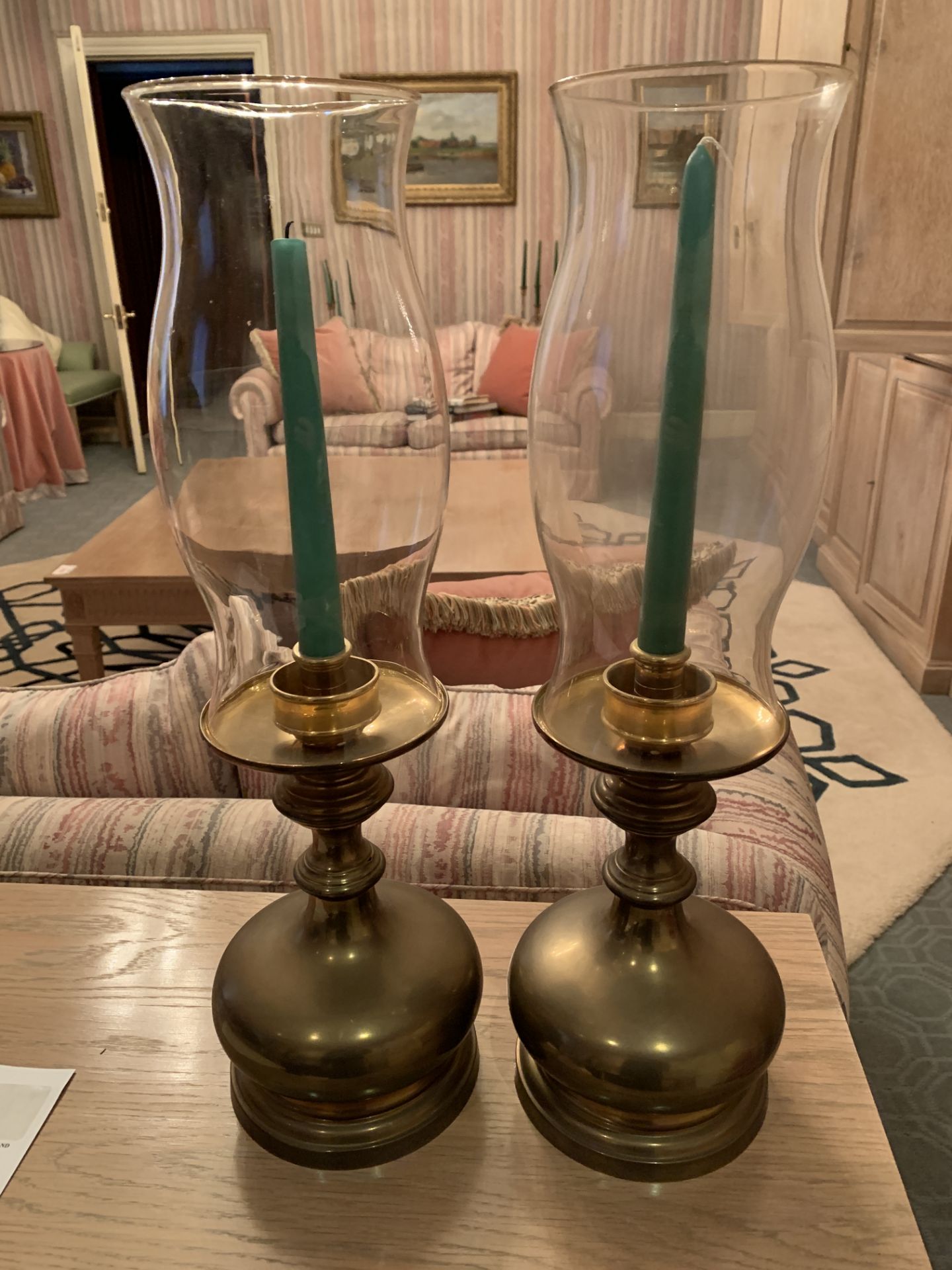 Pair of brass candlesticks with glass storm shades