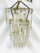 Three tier chandelier with cut glass droplets together with a pair of brass wall lights