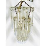 Three tier chandelier with cut glass droplets together with a pair of brass wall lights