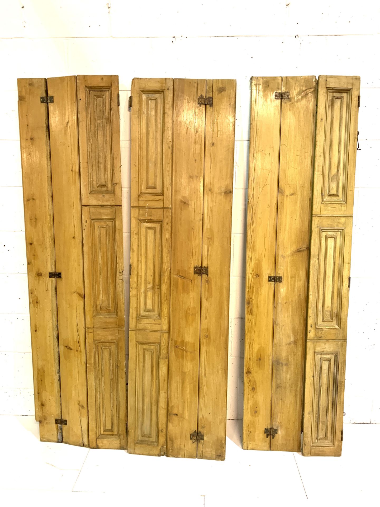 Three pairs of triple folding pine window shutters