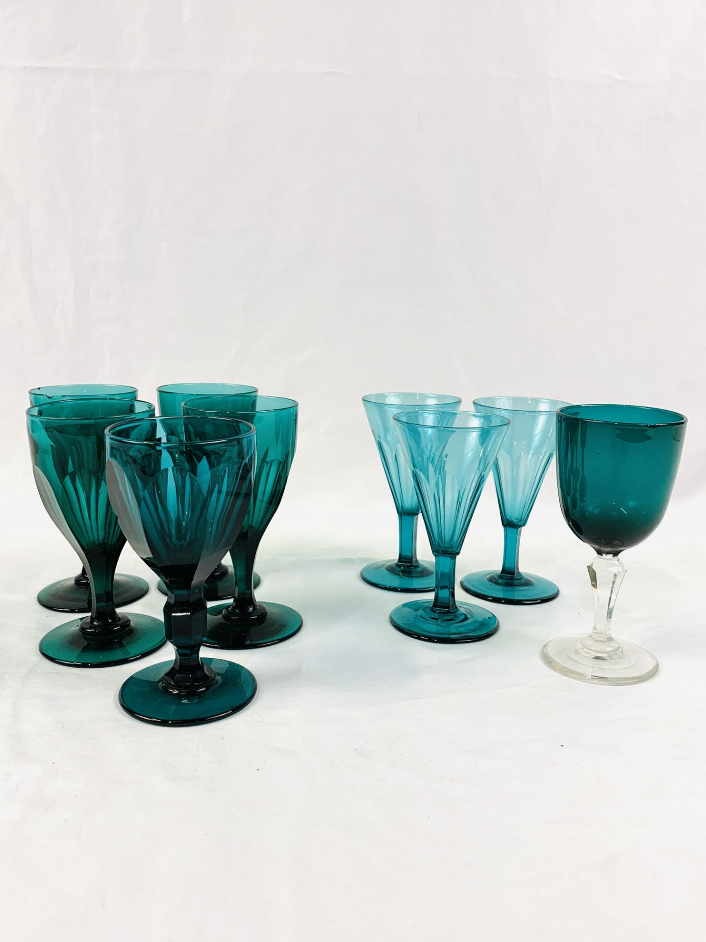 Nine Victorian green glass wine glasses.