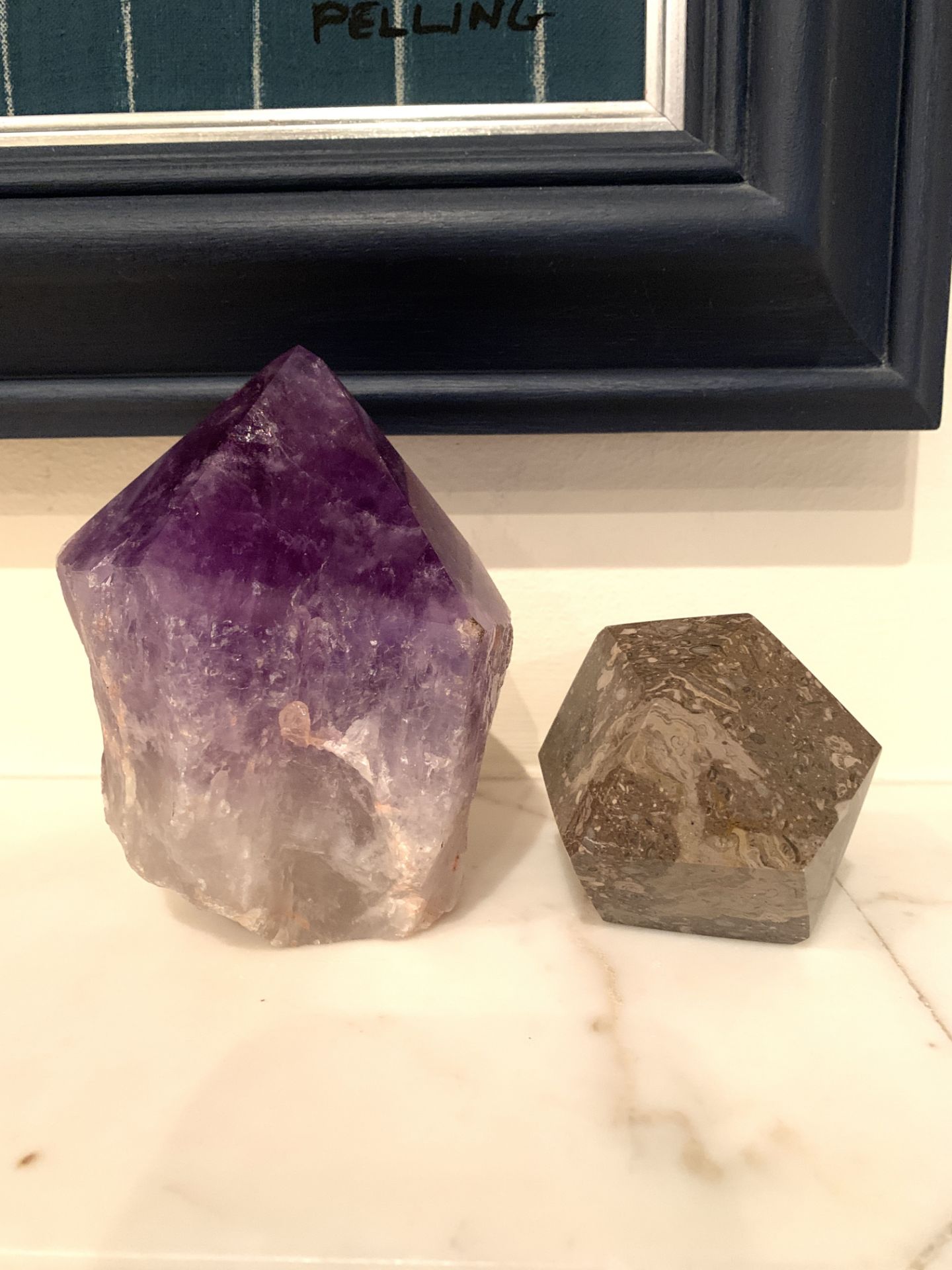 A piece of amethyst and a piece of multi-faced brown marble
