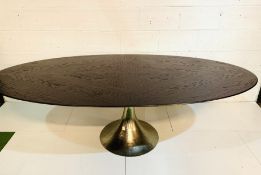 Large oval top dining table on silver coloured metal pedestal