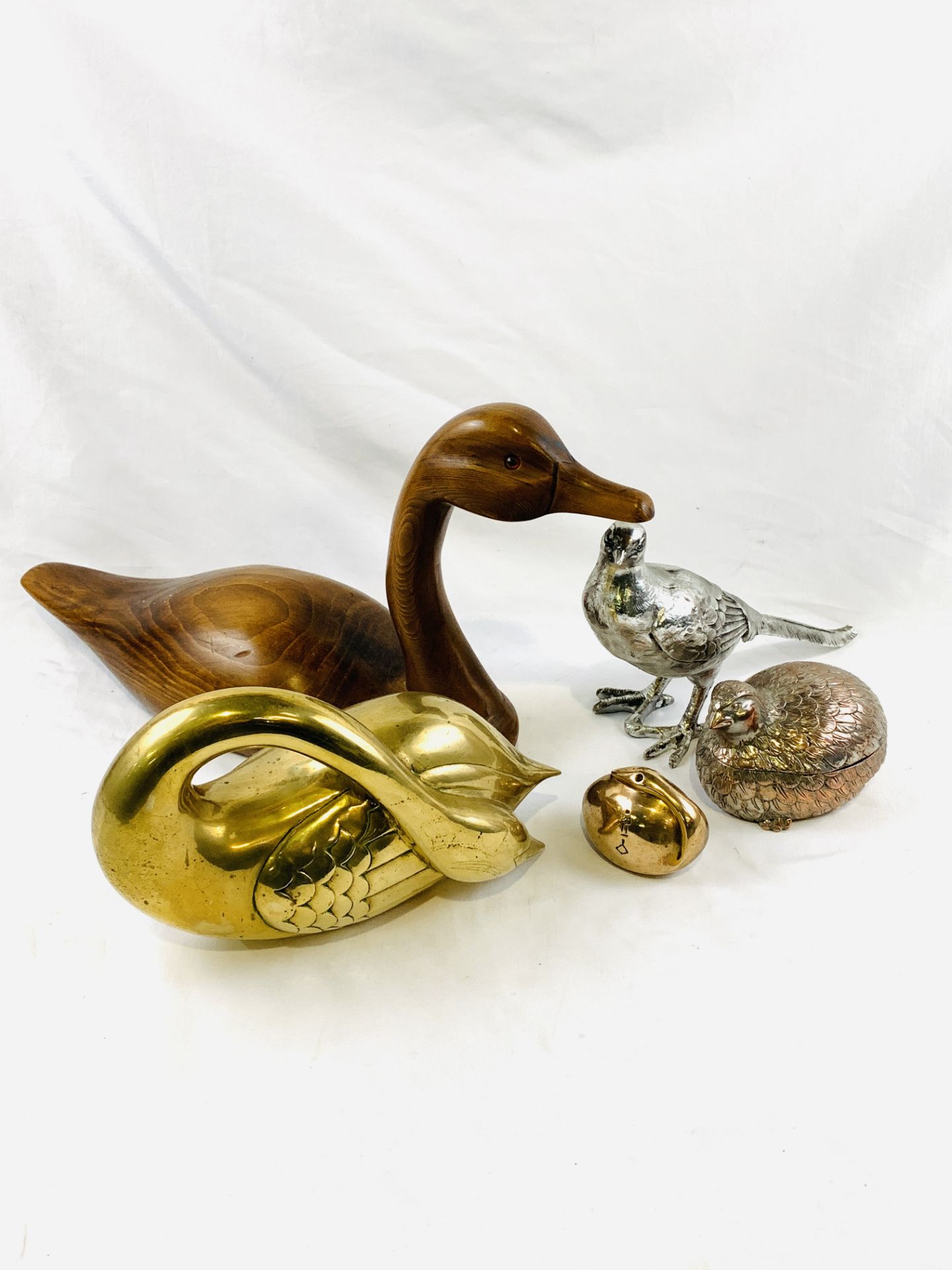 Brass swan figure; wooden carved duck; silver plate partridge dish; swan paperweight; and other.