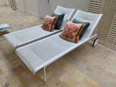 Two white rattan style sun loungers with reclining backs