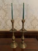 Pair of gilt metal candlesticks with glass storm shades