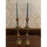 Pair of gilt metal candlesticks with glass storm shades