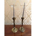 Pair of gilt metal candlesticks with glass storm shades